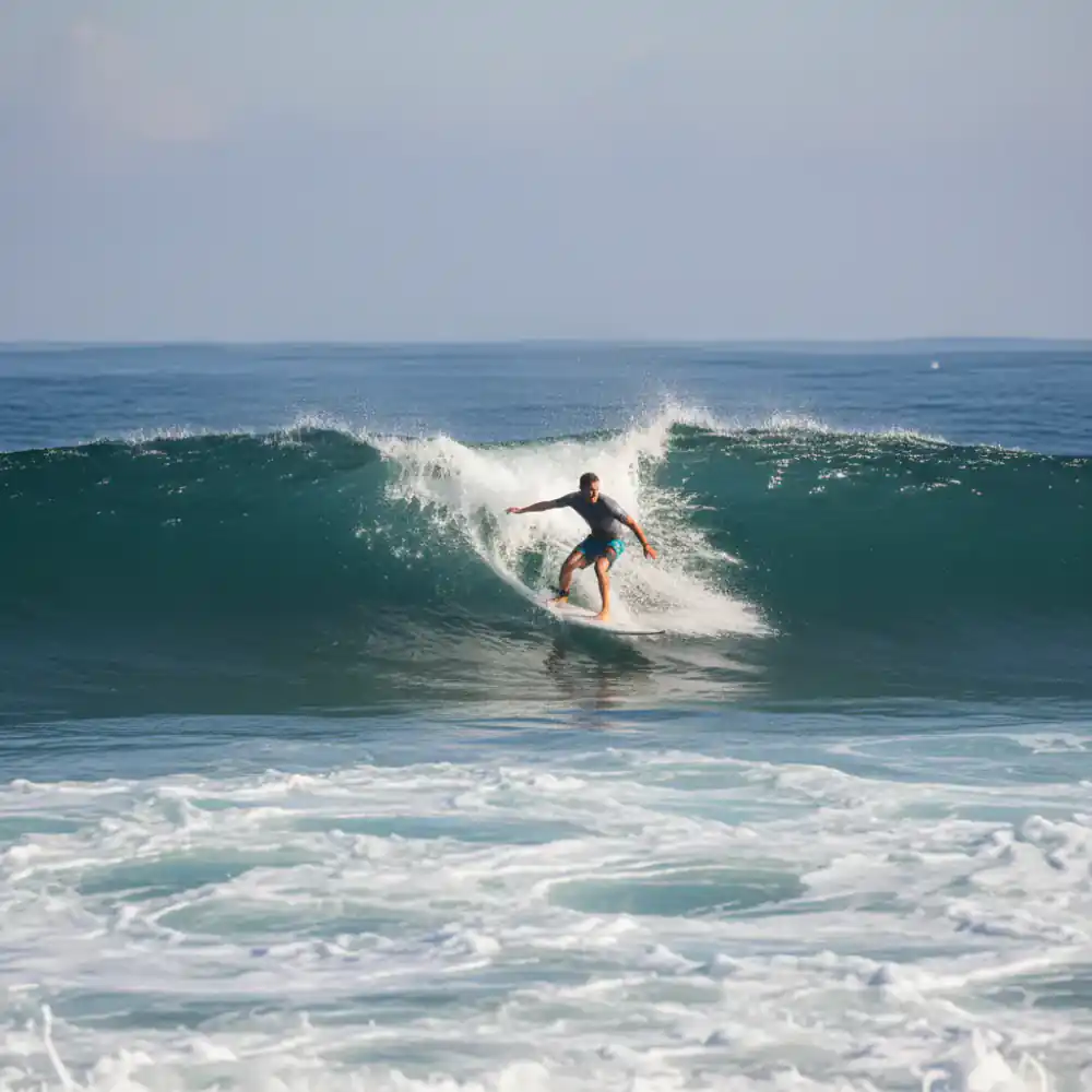 Surfer riding white water in a balanced stance