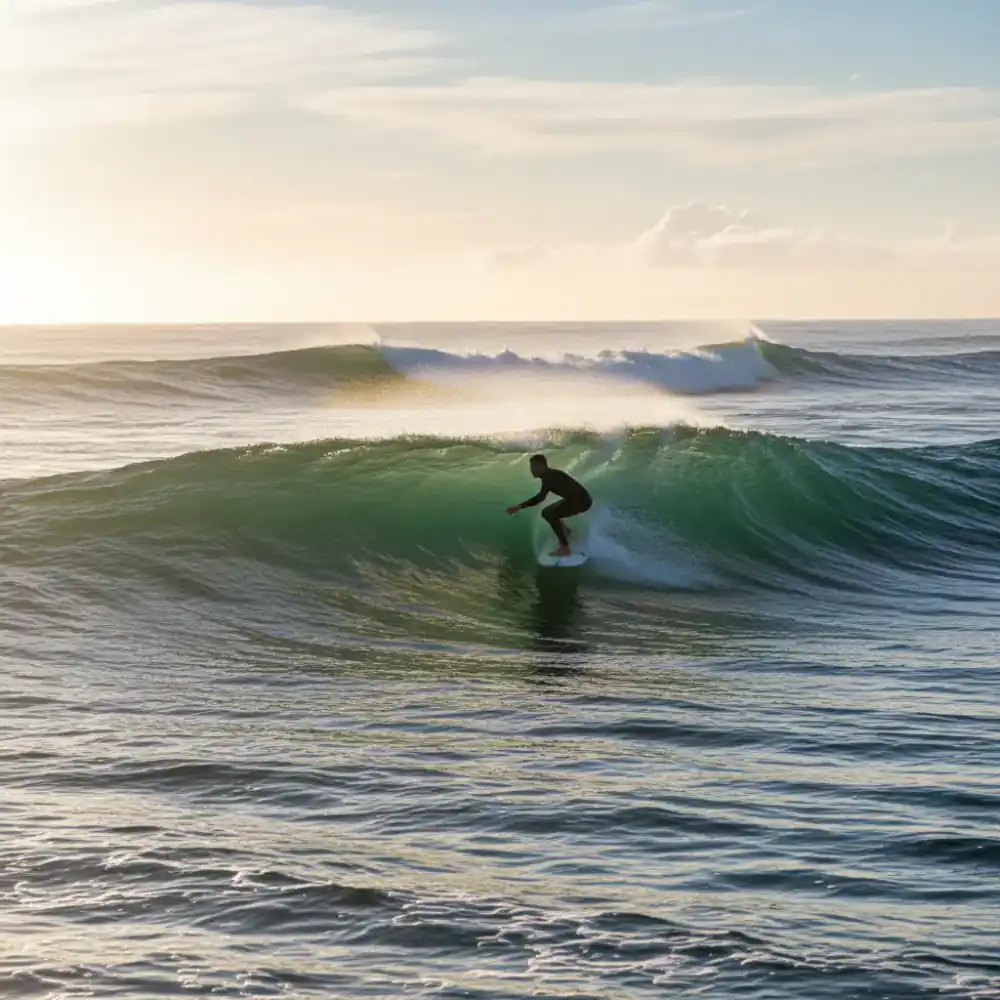 Surfer taking off on an unbroken green wave