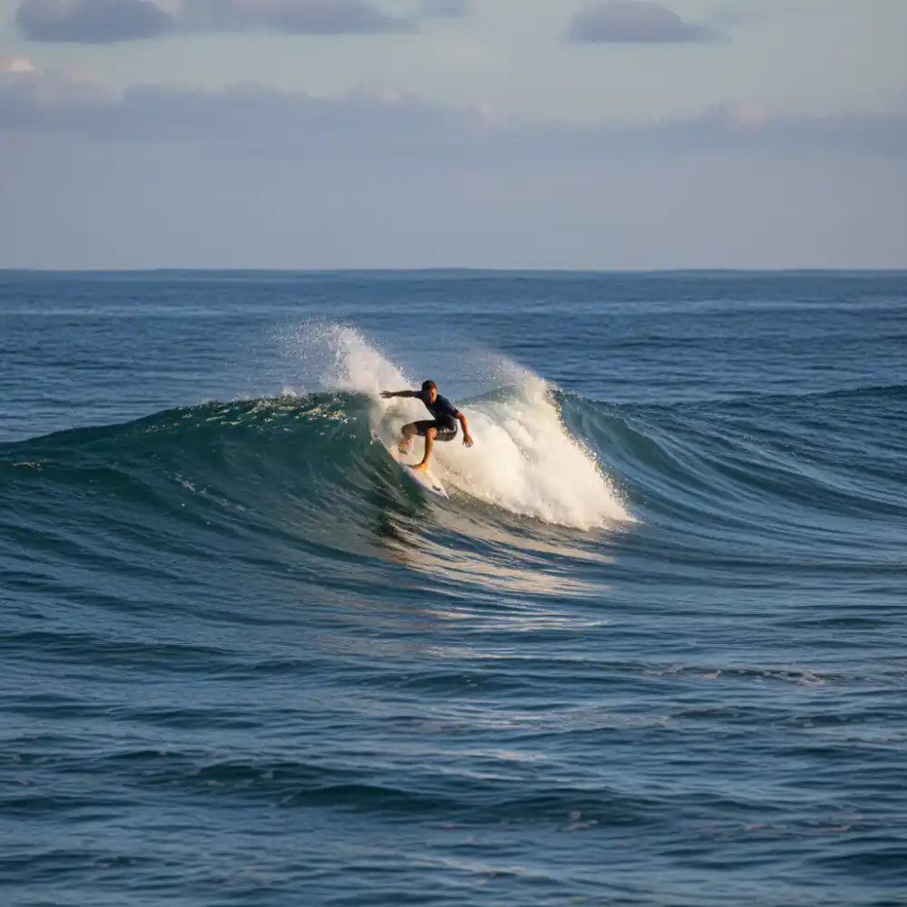 Surfer executing a clean turn on a clear ocean wave